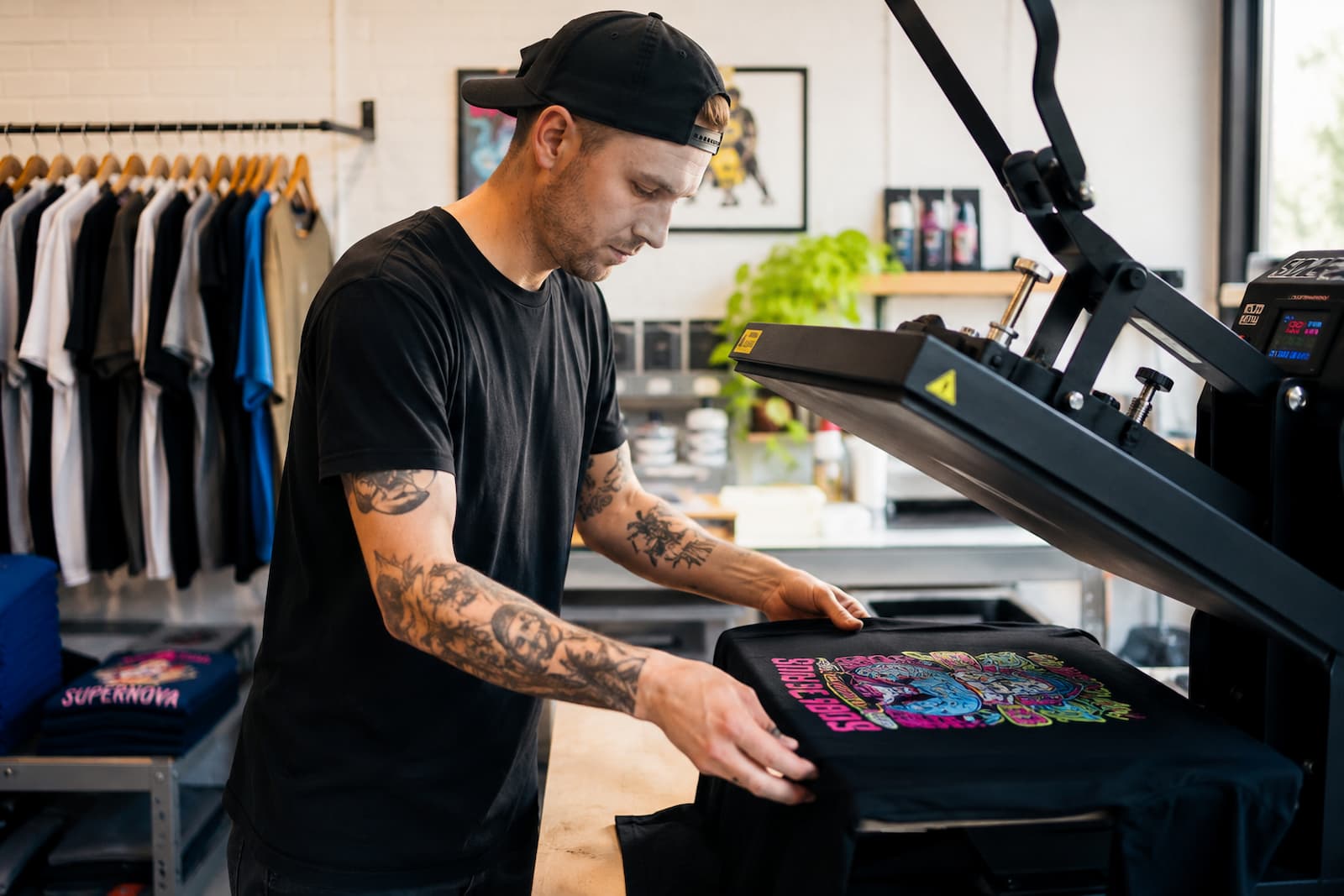 Entrepreneur using a heat press machine with premium DTF white ink for custom apparel