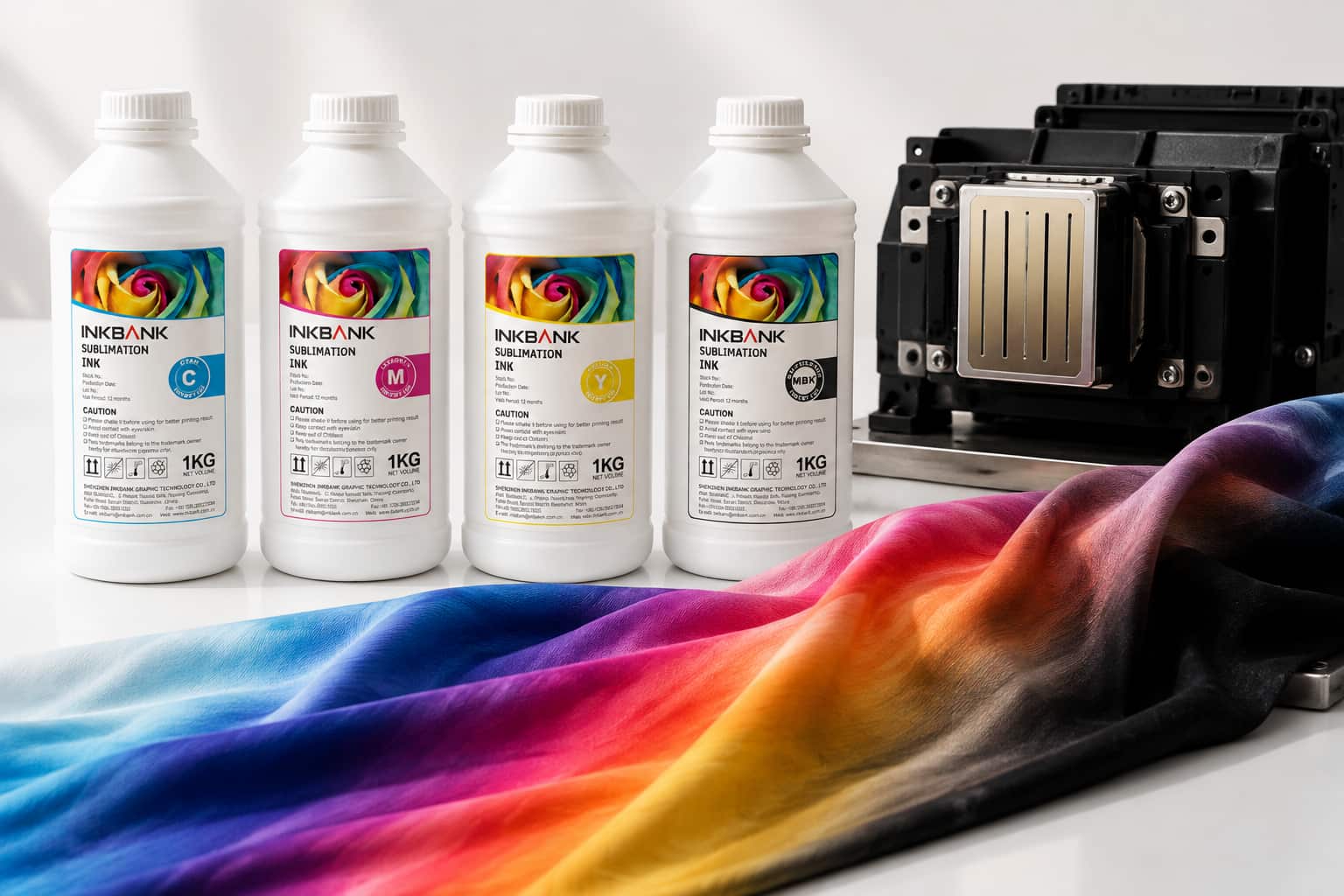 CMYK sublimation ink bottles on a clean white surface beside an industrial inkjet printhead, with vibrant printed polyester fabric draped alongside — studio lighting